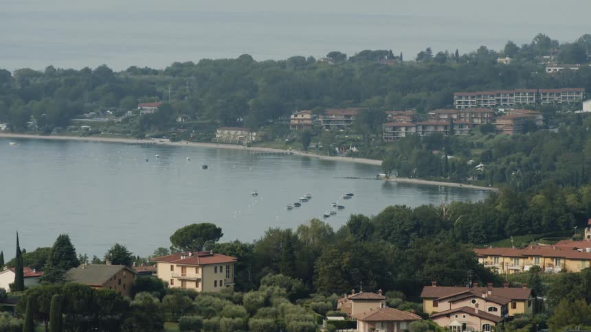 The lake sits surrounded by trees and buildings