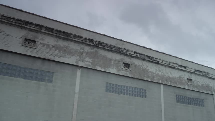 A row of garage doors on an old industrial building on a cloudy day