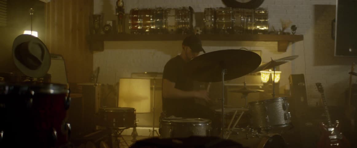 A person is playing the drums indoors