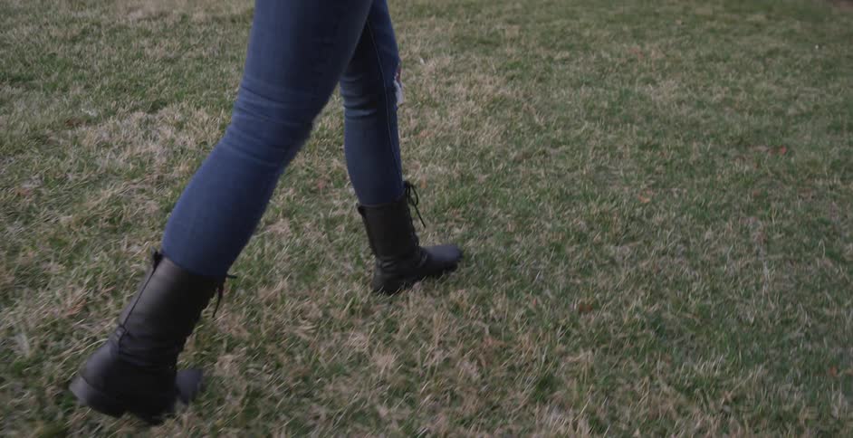 A woman walks over to a tombstone