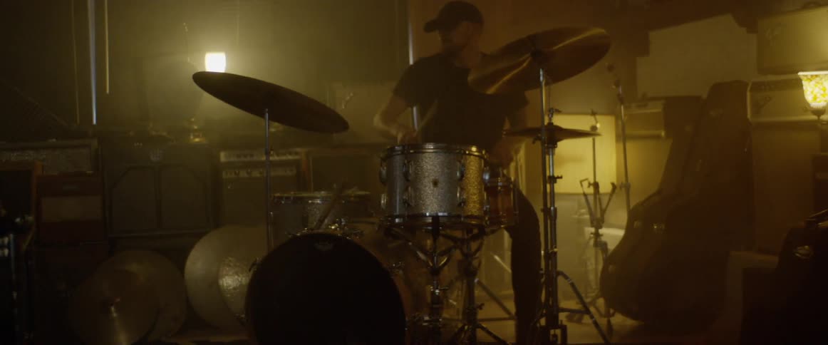 A man plays the drums in a building