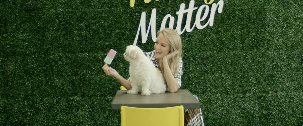 A woman is petting a dog outdoors