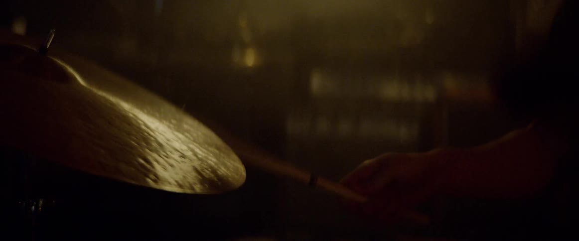 A person playing on a beat up taped drum kit