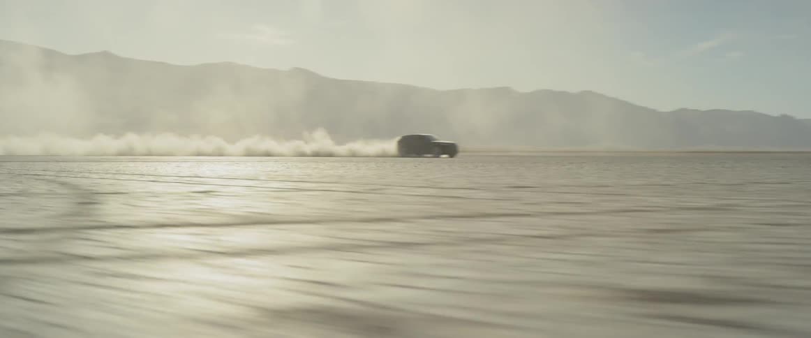 A vehicle is racing in the desert