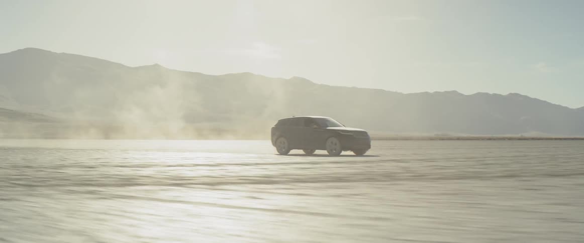 A black range rover sport driving across the salt flats