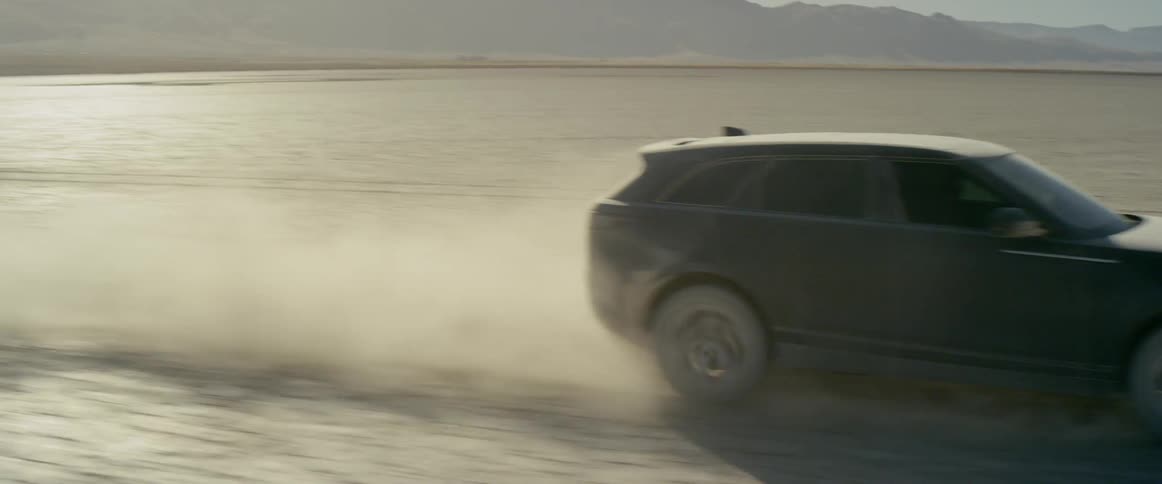 A black range rover sport speeds across the desert landscape