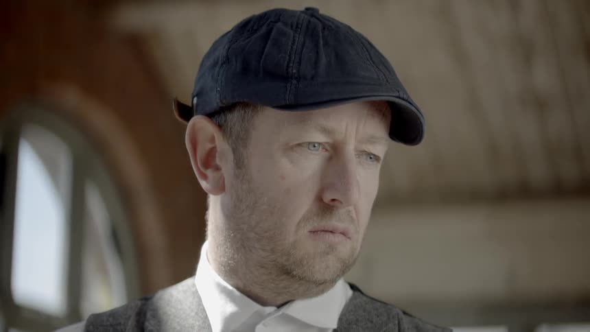 A man is in a room wearing a hat