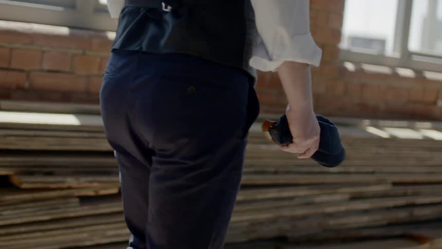 A man walks by a building with a sheathed knife in his hand