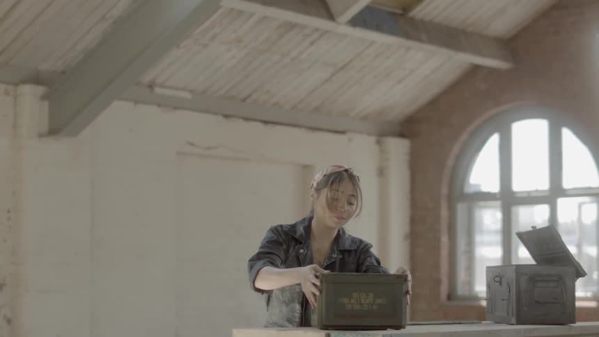 A woman is carrying boxes in a house