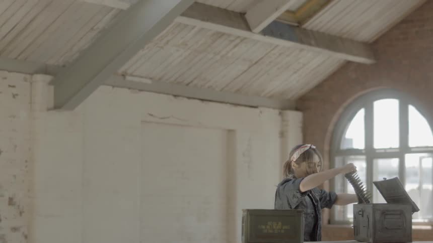 A young girl pulls bullets out of a box