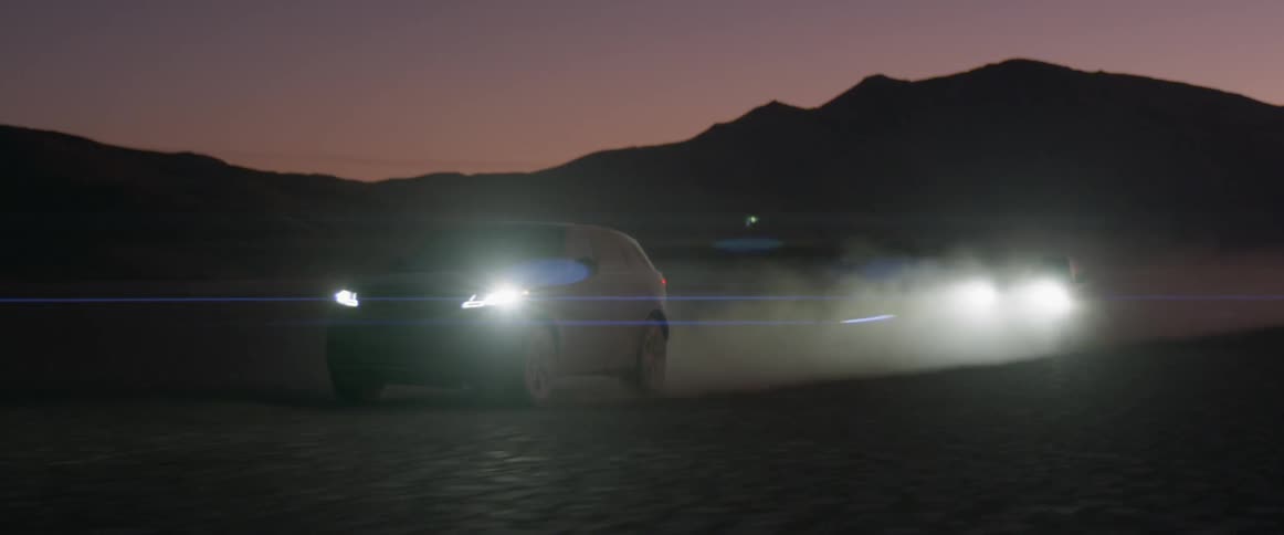Cars race in the desert at night