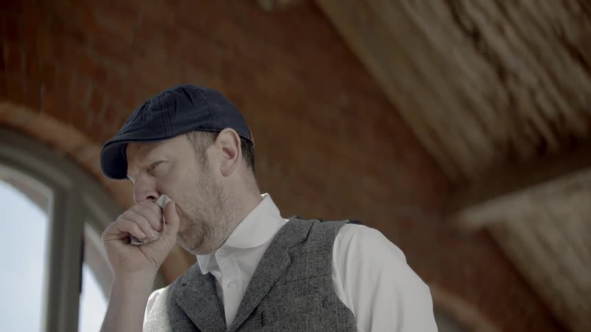 A man coughing into a rag