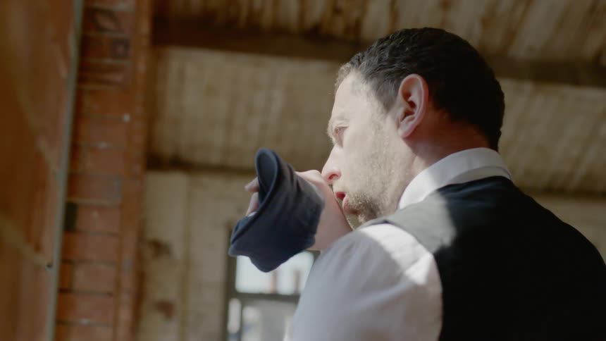 A man blowing off a piece of cloth