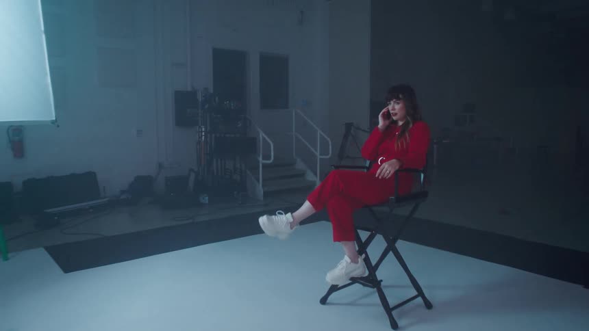 A woman sitting in a chair talking on a phone