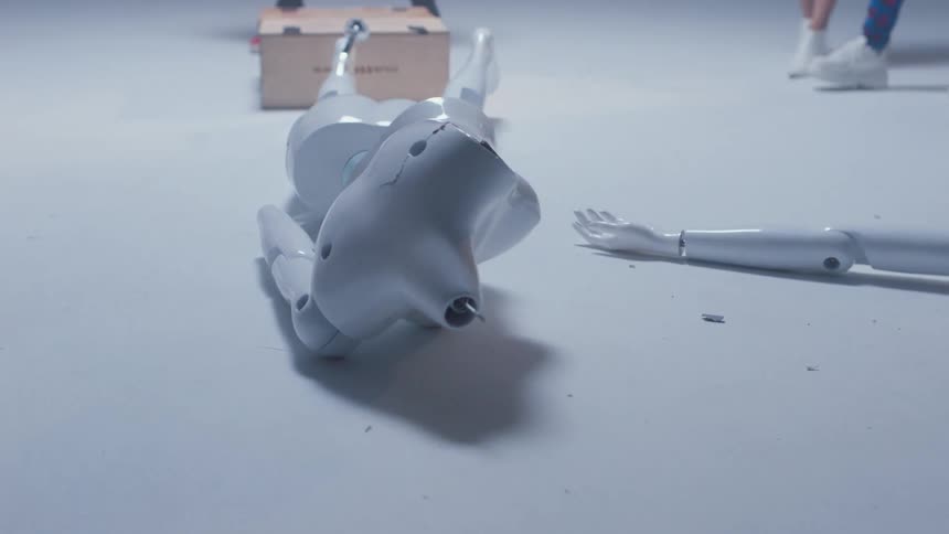 A group of woman stand around a white mannequin after one of them pushes it over and it breaks on the ground