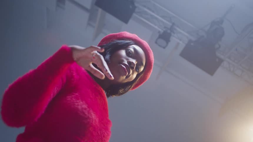 A young black woman dances for the camera