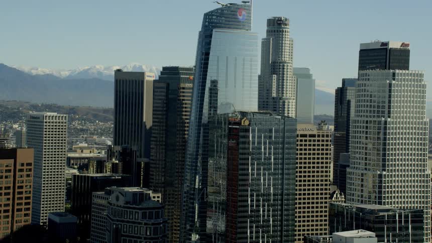 Aerial reveal of Downtown Los Angeles with snow capped mountains in the background