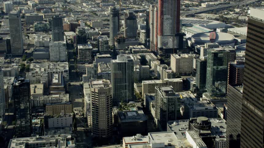 Aerial fly by of Skyscrapers and building rooftops in a city