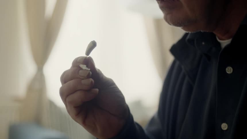 An elderly takes out his hearing aid and sets it on the piano