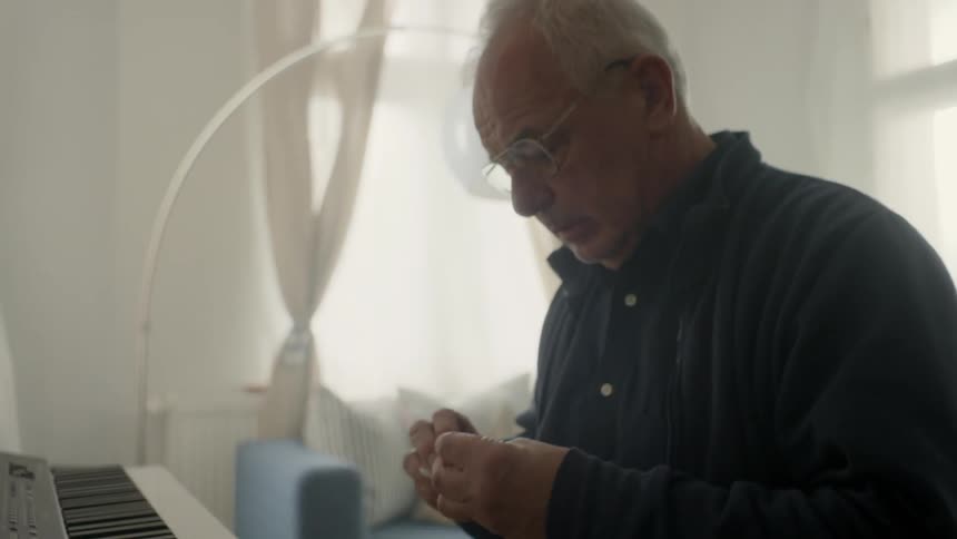 A man is sitting at a keyboard preparing to play