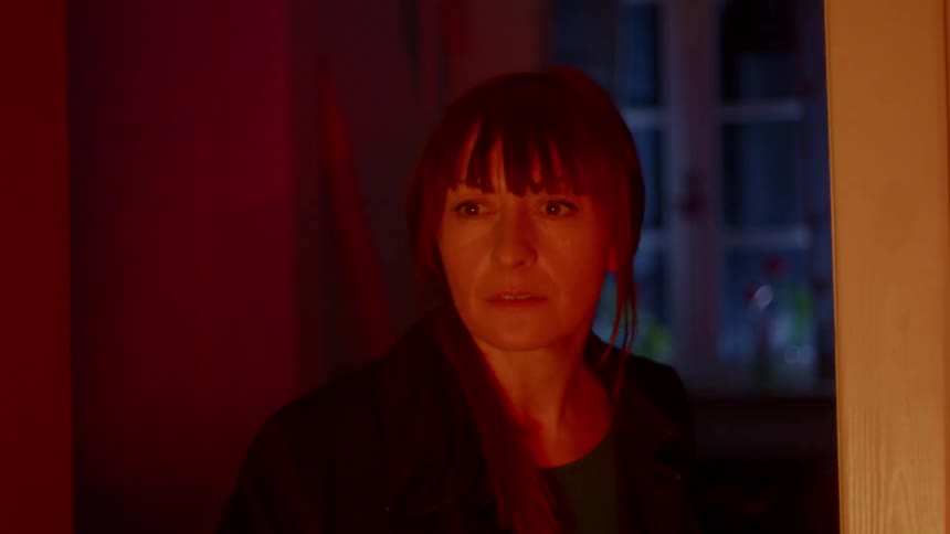 A woman opens an interior door and smiles when colorful lights glow
