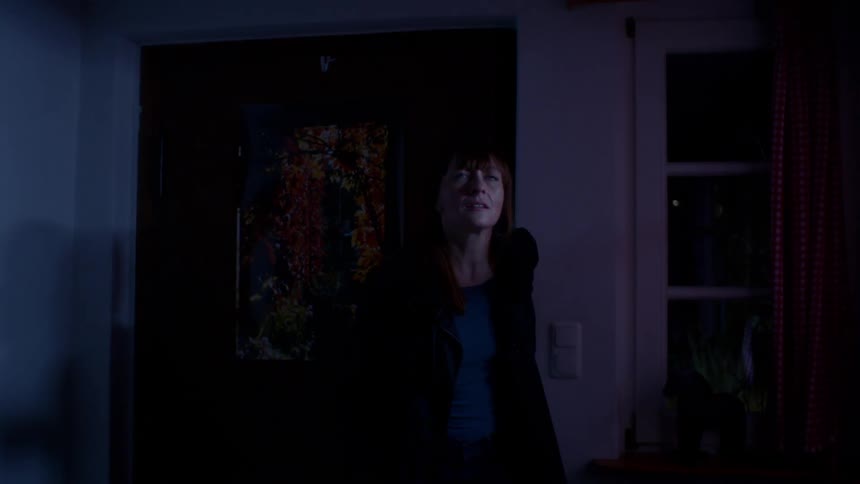 A woman walks into her house and is worried that the light switch does not work