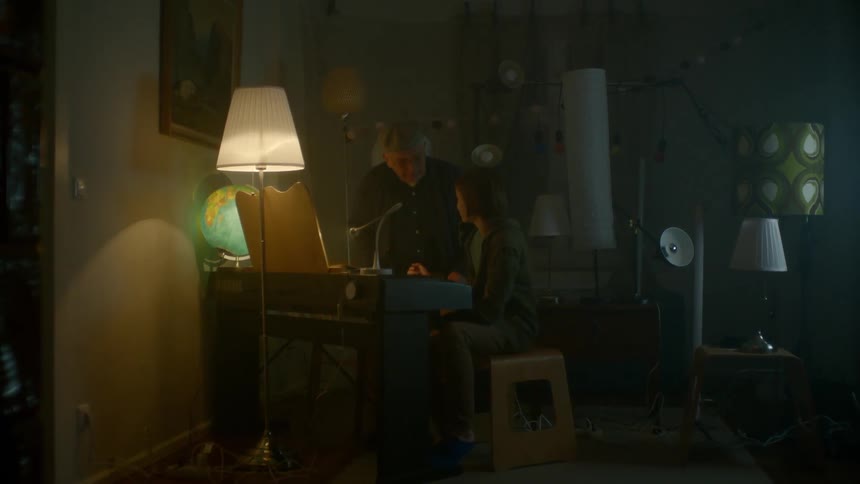 Grandfather and grandson sit at keyboard and play with lighting