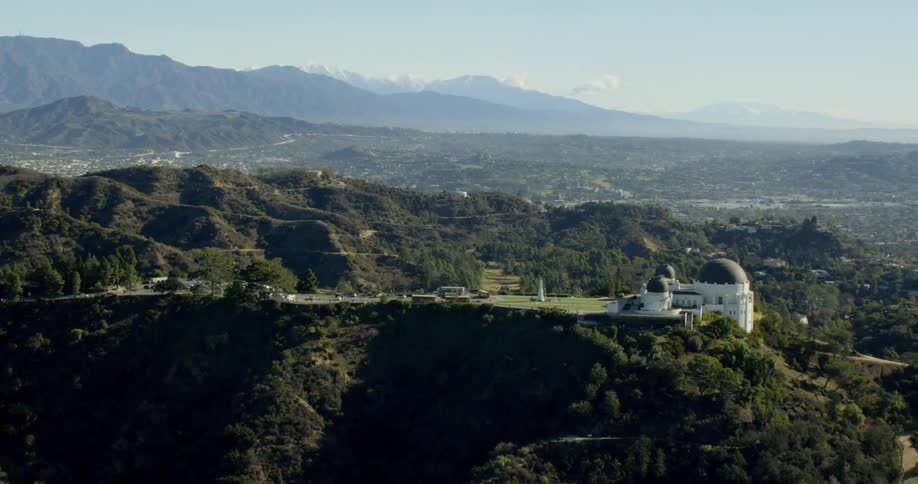The Griffith Observatory with a backdrop of snow capped mountains