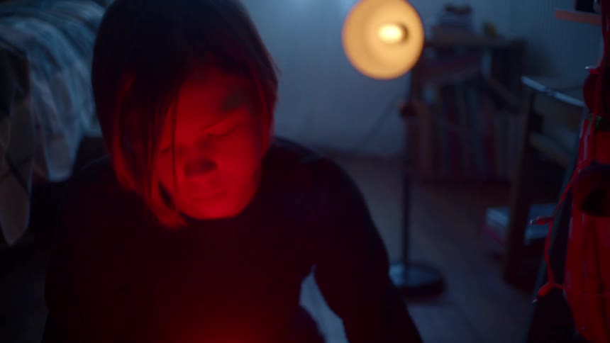 A young boy holds a red light