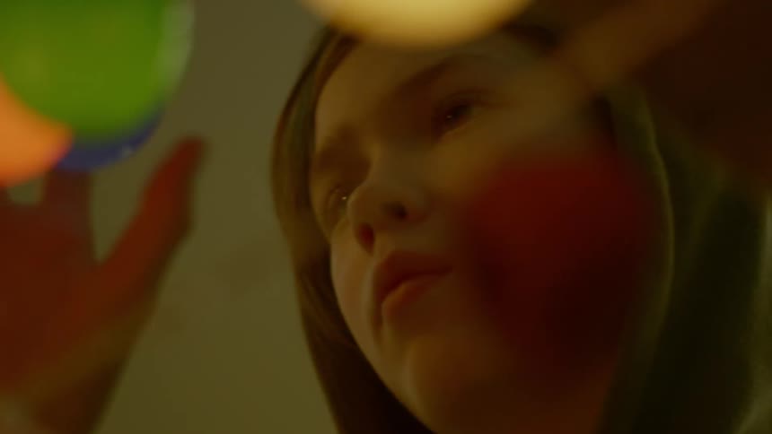 A girl screws in multi colored light bulbs