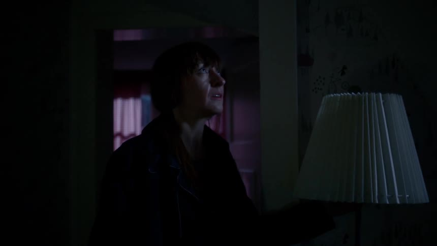 Woman walks through the dark house and opens the door