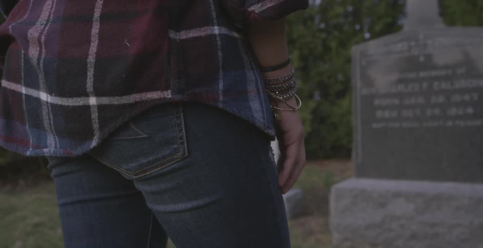 A woman looks at a headstone