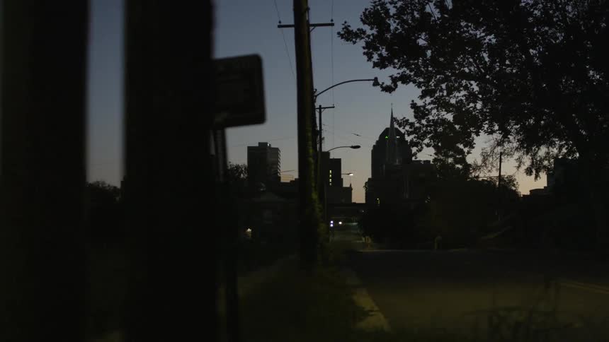 A sidewalk and a road on a cloudy night in the city