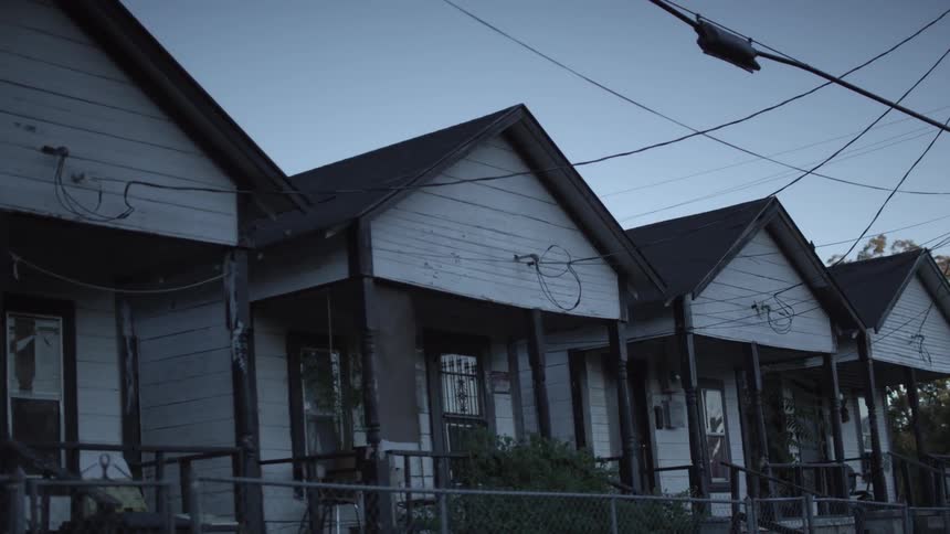 A row of identical older houses with electrical cables
