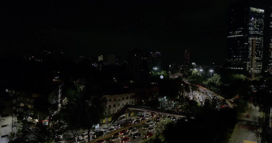 Cars stuck in traffic on a highway leading away from a city at night