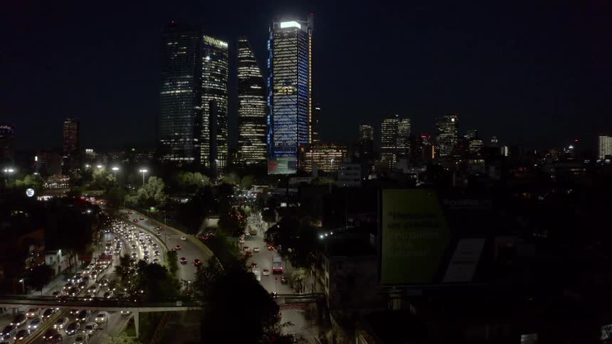 Cars travel on city streets while others are stuck in traffic in a city at night