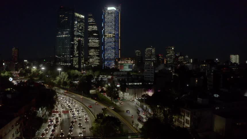 Cars travel in and out of the city on highways at night