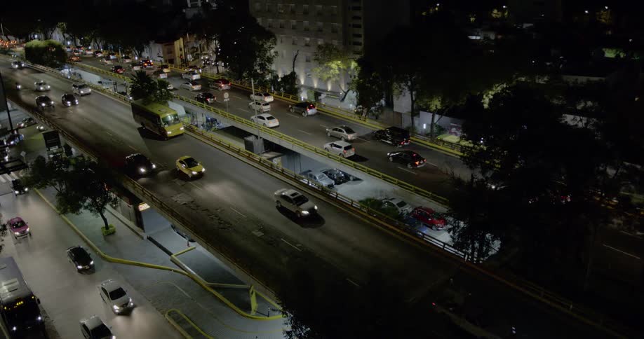 Cars trucks and buses travel on highways in and out of the city at night