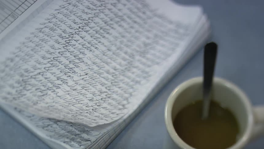 Cup of coffee next to a ledger