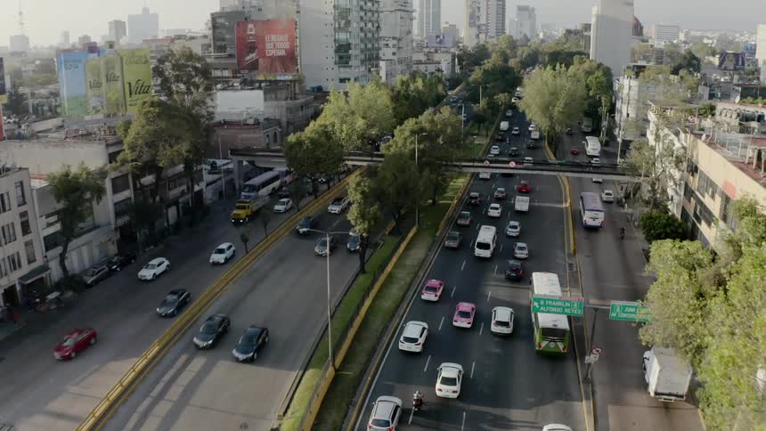 Heavy traffic can be seen from above as it moves through a large urban city