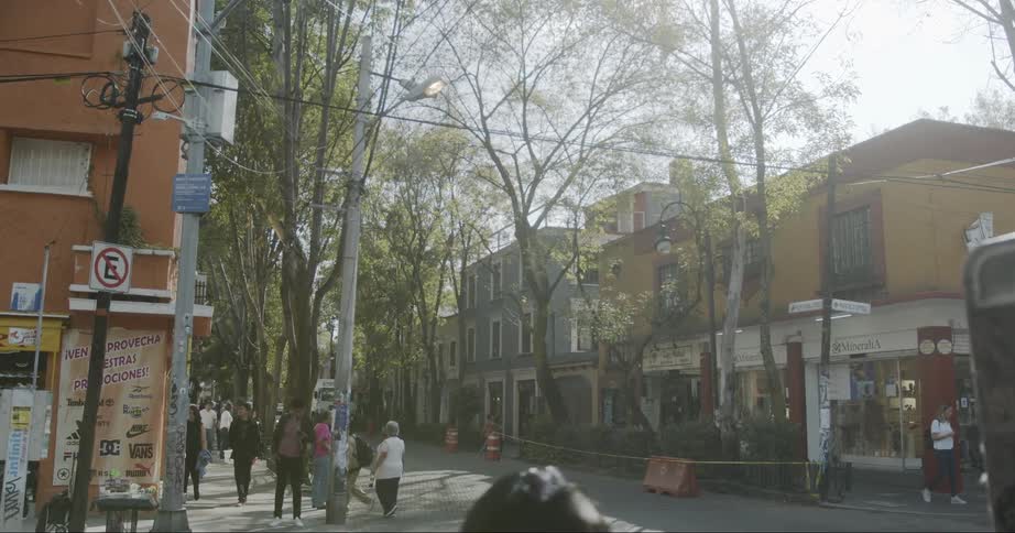 Pedestrians walk among mid rise building shops