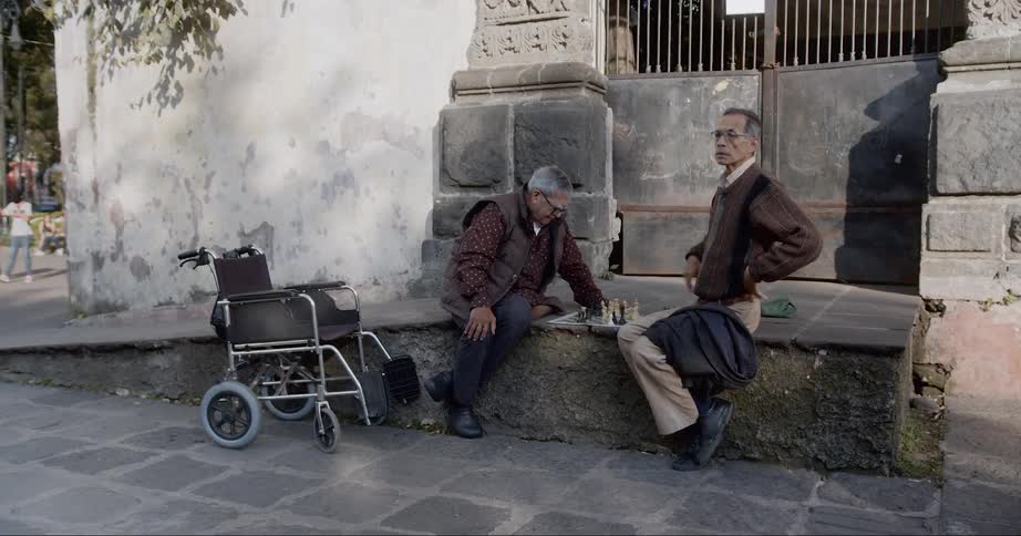 Two men are sitting on a bench outdoors