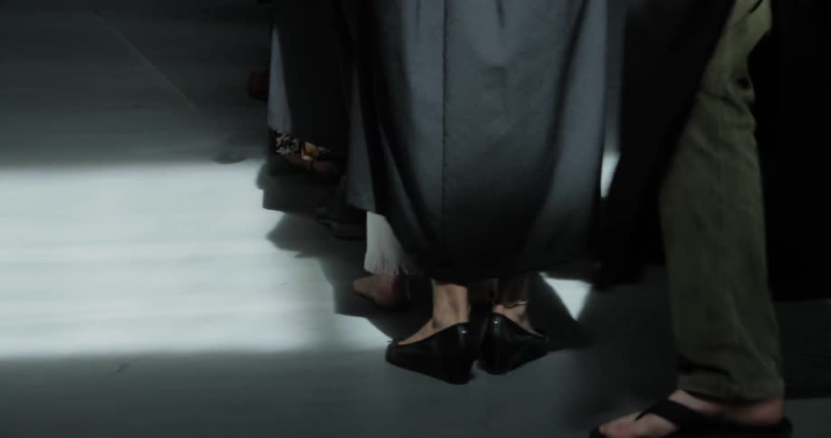 A number of women in long dresses form a line