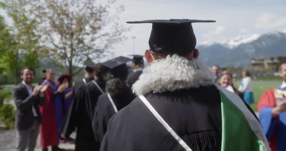 The graduates walk in line outside