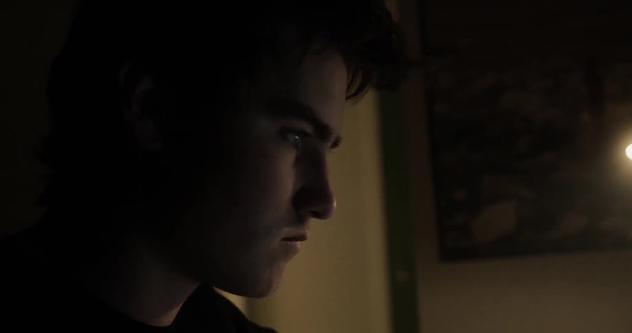 A white man stares at a laptop screen while he types