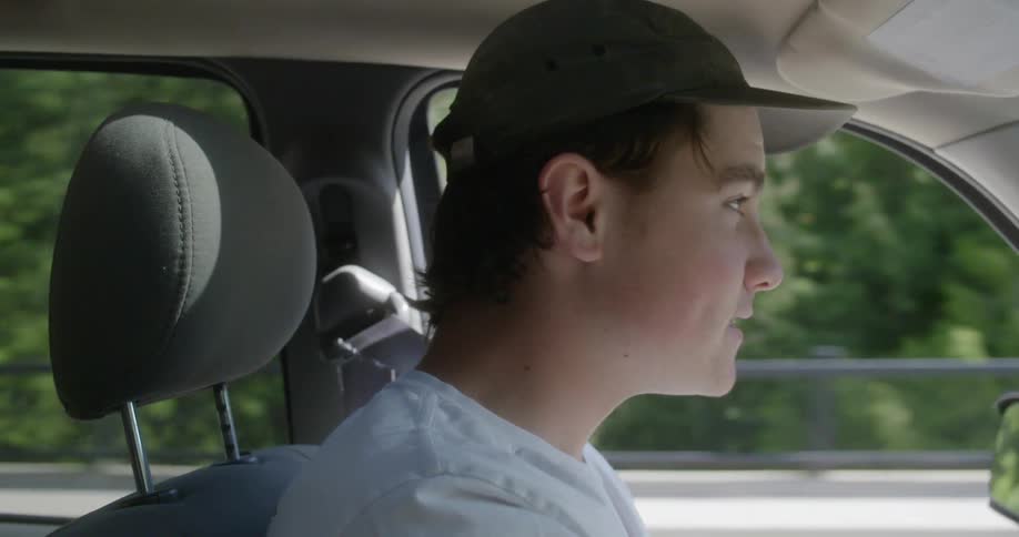 A teenager looks around while driving