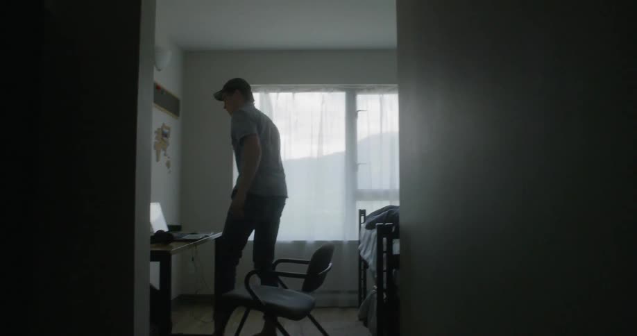 A young man gets up out of a chair and paces the room