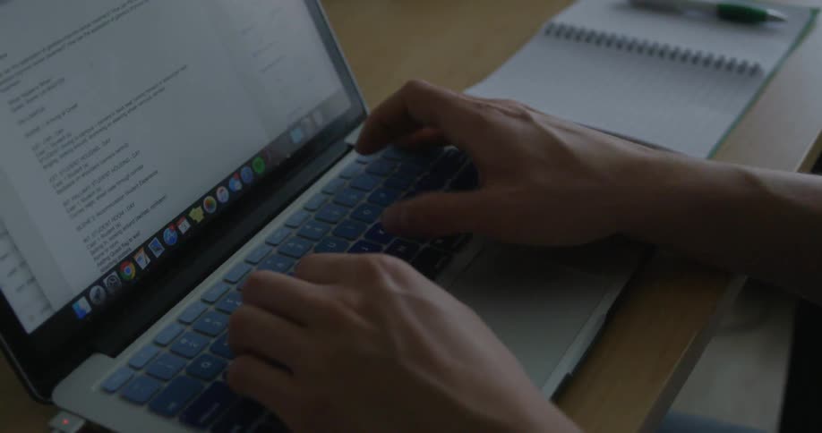 A man typing in his laptop