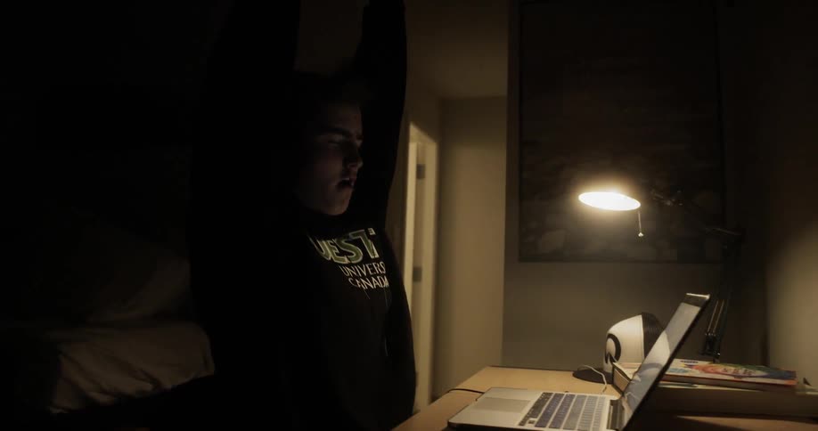 A man stops typing to stretch then goes back to working on his laptop