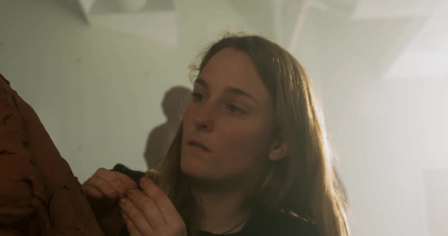 A young girl works on a sculpture